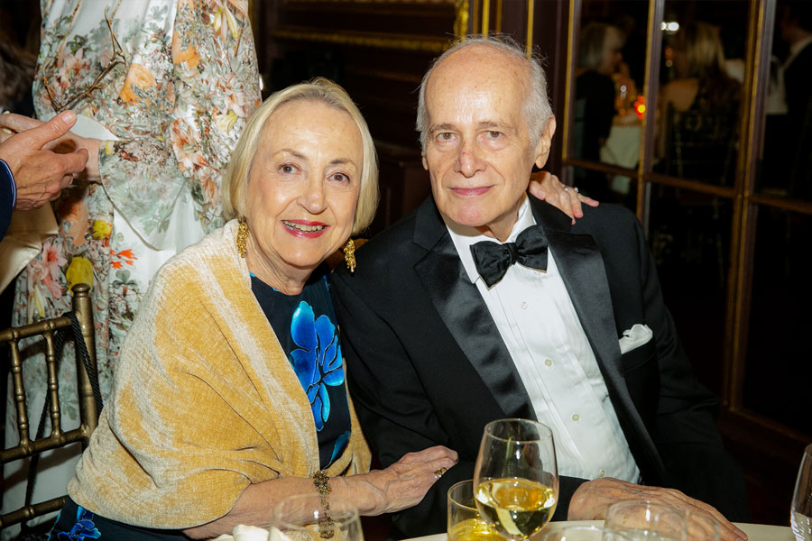 A man and a woman are seated and smiling at the camera during the 2019 Gala