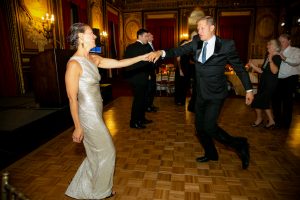 A man in a suit twirls a woman in a silver dress at the 2019 Gala