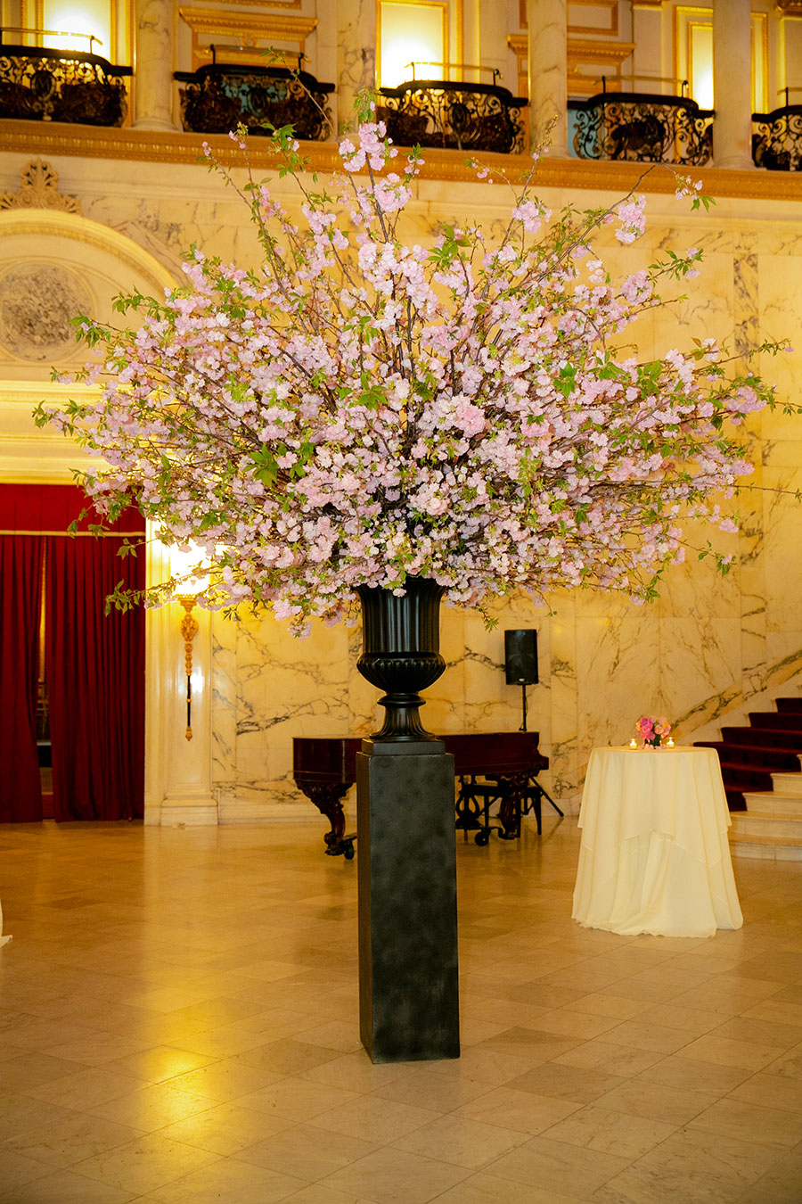 Black vase centerpiece with pink flowers in lobby