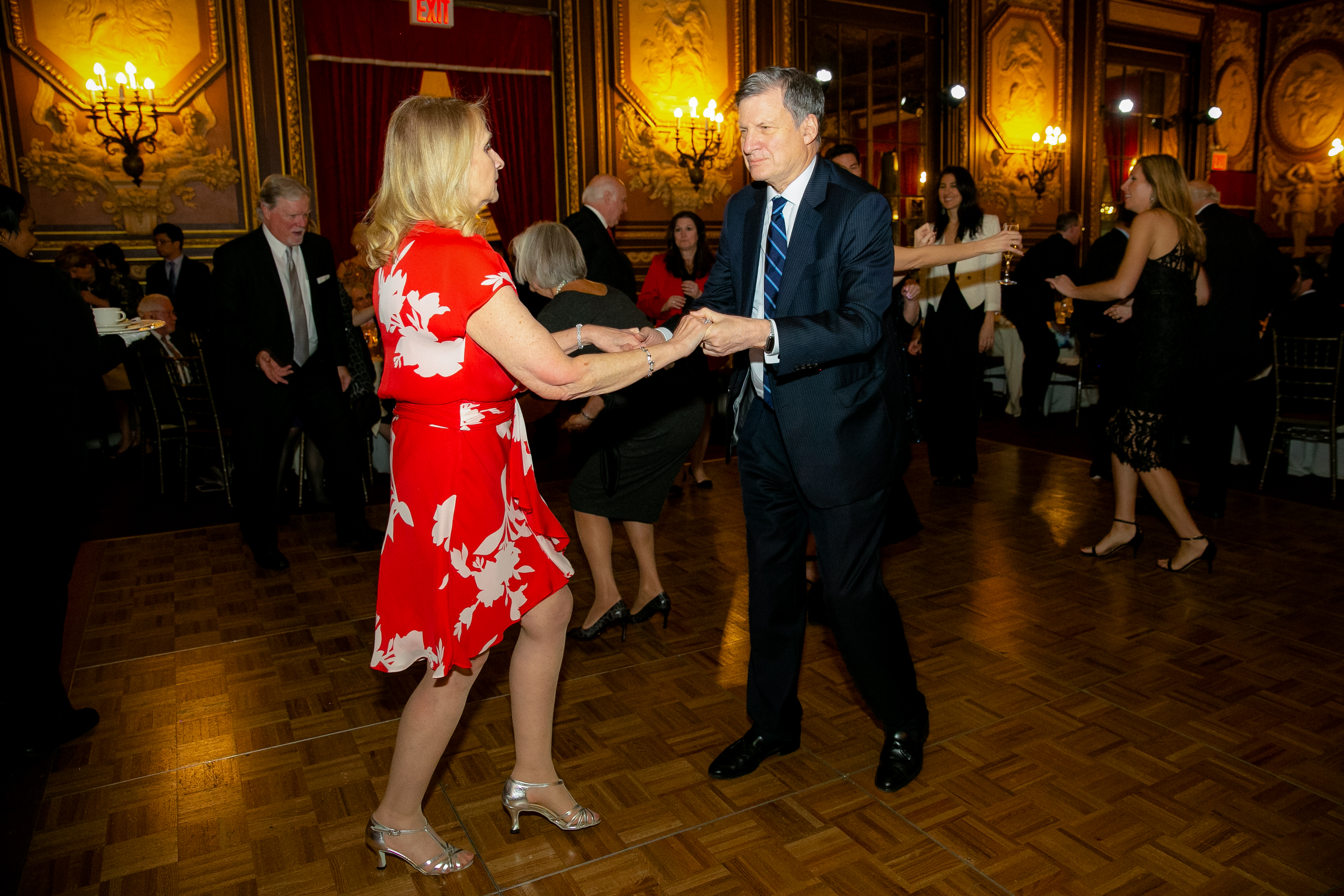 A man and a woman dancing with people behind them at 2019 Gala